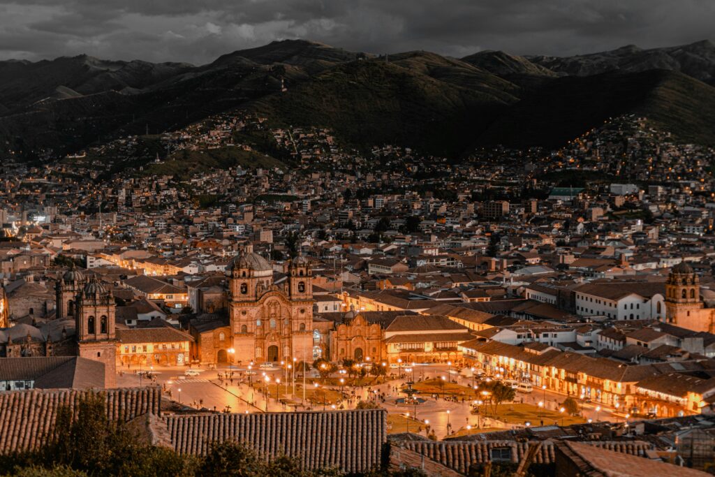 pexels-photo-16756520-16756520 Aerial view of Cusco, Peru at twilight showcasing illuminated buildings and historic architecture.