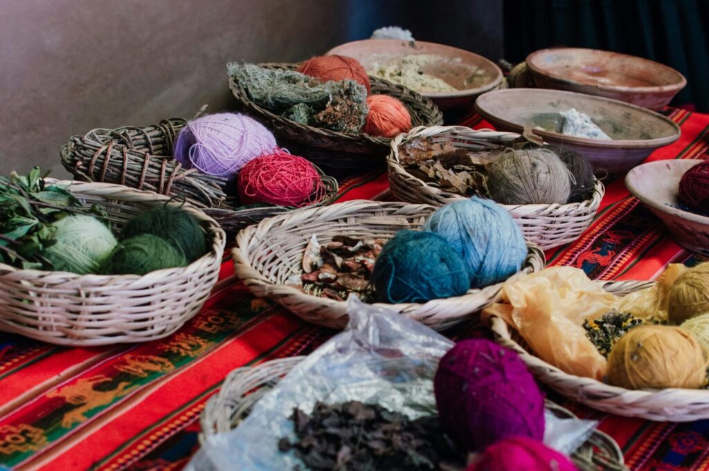 Vibrant display of traditional Peruvian textiles and natural dyes at a market in Cusco.