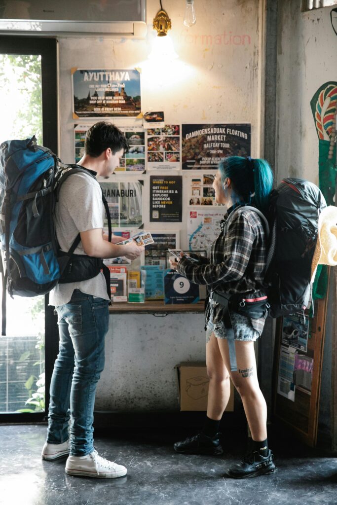 pexels-photo-7968285-7968285 A young couple with backpacks examining travel brochures indoors, planning their next urban adventure.
